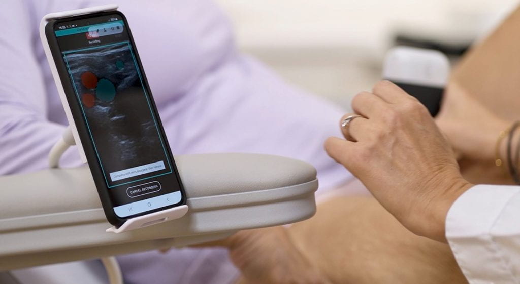 Close up of a health professional sitting next to a patient with the imaging app in the foreground.